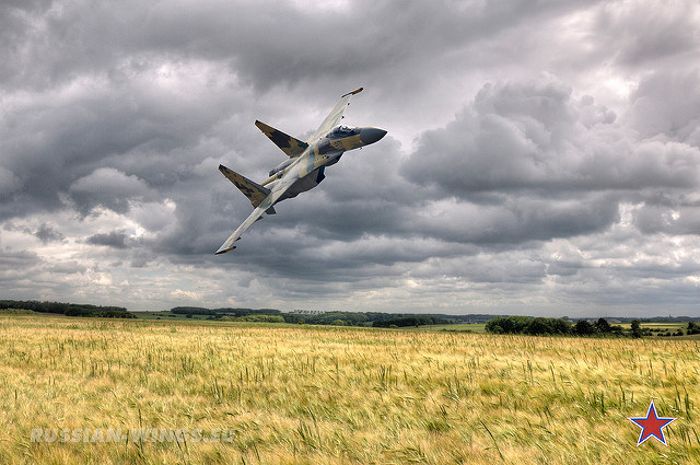 Su-35 carving over cornfields